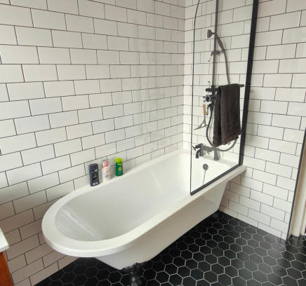Victorian style free standing bath, black hexagon floor tiles, white metro wall tiles and black fittings